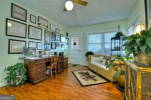 office space featuring ceiling fan, hardwood / wood-style flooring, and a textured ceiling