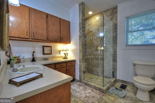 bathroom featuring a shower with door, a textured ceiling, toilet, ornamental molding, and vanity