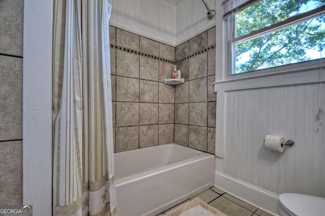 bathroom featuring shower / bath combo with shower curtain, toilet, and tile patterned flooring