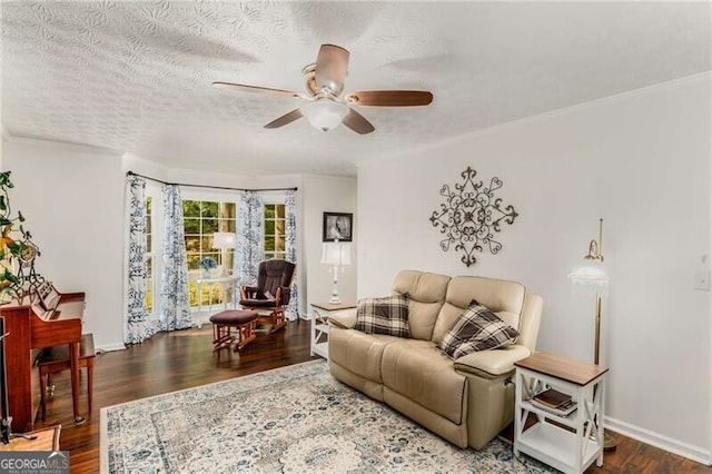 living room with a textured ceiling, ceiling fan, and dark wood-type flooring