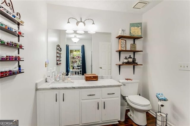 bathroom with hardwood / wood-style flooring, vanity, and toilet