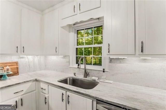 kitchen with white cabinetry, sink, dishwasher, light stone counters, and ornamental molding