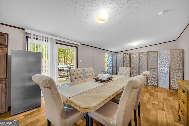 dining space featuring light hardwood / wood-style floors, crown molding, and a textured ceiling