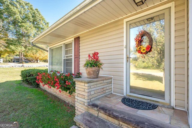 property entrance featuring a lawn