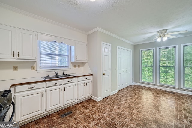 kitchen featuring black range oven, sink, white cabinets, and ceiling fan