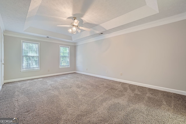 unfurnished room featuring crown molding, a tray ceiling, and carpet