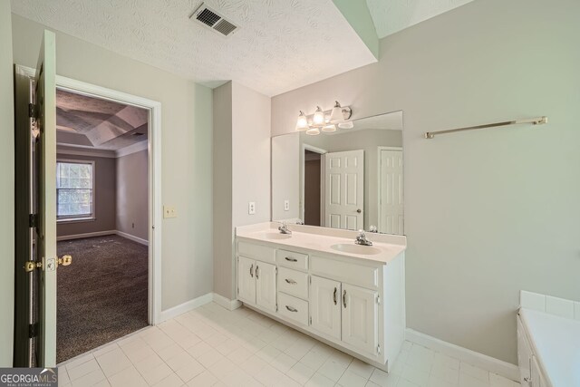 2459 Jacks View Ct, Snellville, GA 30078 - bathroom with double vanity, baseboards, a textured ceiling, and tile patterned floors