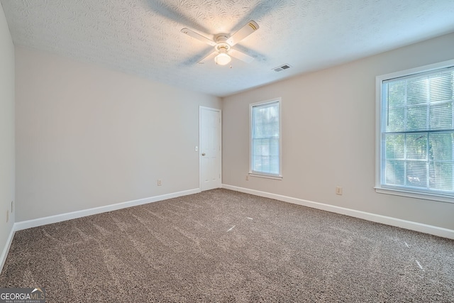 carpeted empty room featuring ceiling fan and a textured ceiling