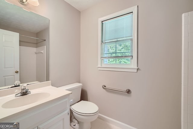 bathroom with toilet, vanity, a shower, and tile patterned flooring