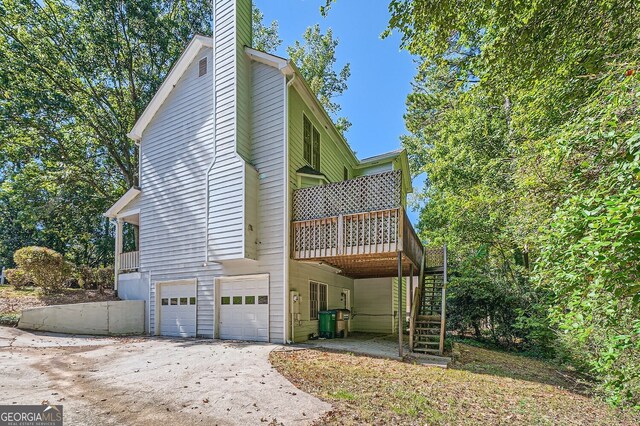 2459 Jacks View Ct, Snellville, GA 30078 - view of home's exterior featuring stairs, an attached garage, a deck, driveway, and a chimney