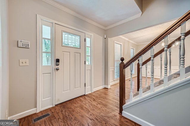 entrance foyer featuring hardwood / wood-style floors and crown molding