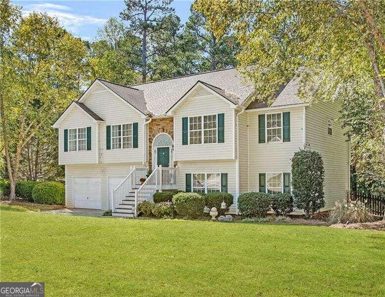 split foyer home with a garage and a front lawn