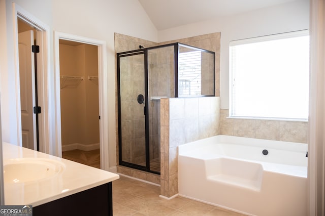 bathroom featuring vanity, independent shower and bath, tile patterned floors, and vaulted ceiling