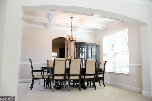 dining space featuring crown molding, coffered ceiling, beamed ceiling, a chandelier, and light colored carpet