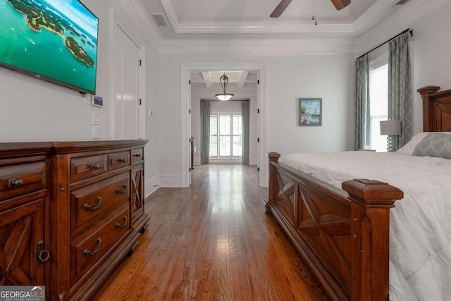 bedroom with ceiling fan, ornamental molding, multiple windows, and hardwood / wood-style floors