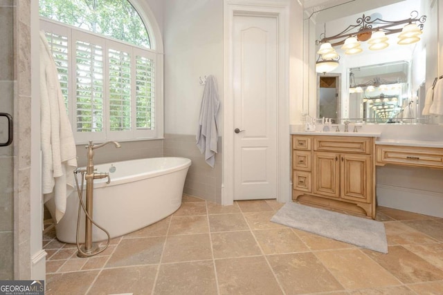 bathroom featuring vanity, a tub, and tile walls