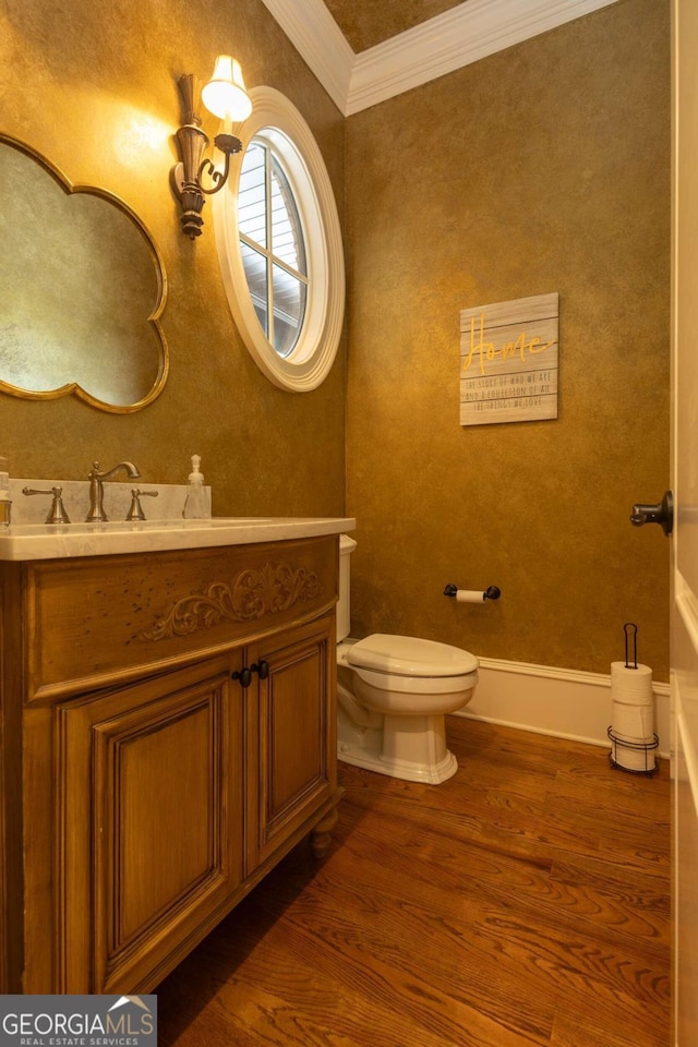 bathroom featuring toilet, crown molding, hardwood / wood-style flooring, and vanity