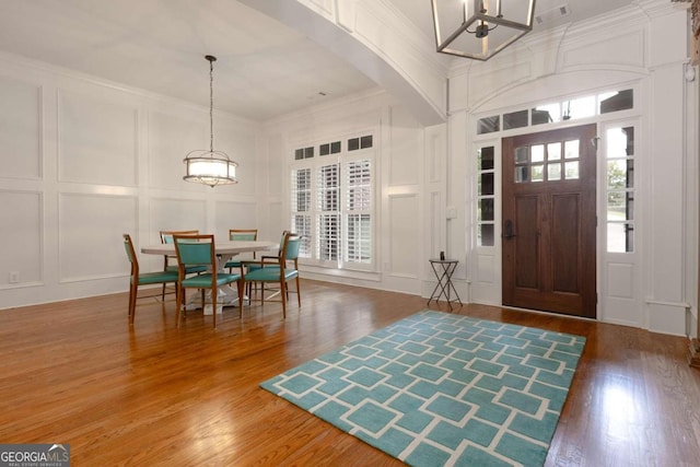 entryway featuring a wealth of natural light, ornamental molding, and hardwood / wood-style flooring