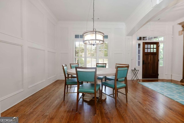 dining room featuring a notable chandelier, ornamental molding, and dark hardwood / wood-style flooring