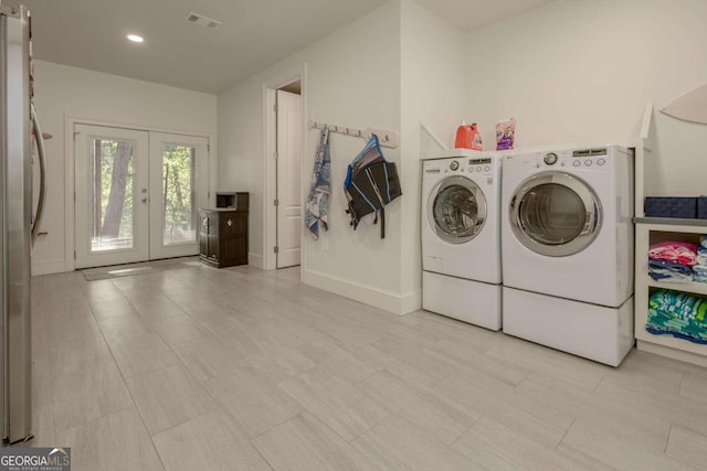 clothes washing area featuring french doors and washing machine and dryer