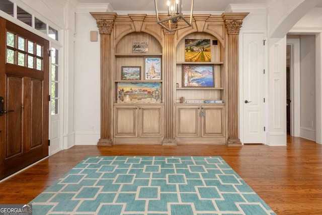 foyer featuring ornamental molding and dark hardwood / wood-style floors