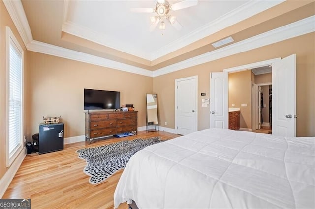 bedroom with ornamental molding, hardwood / wood-style floors, a raised ceiling, and ceiling fan