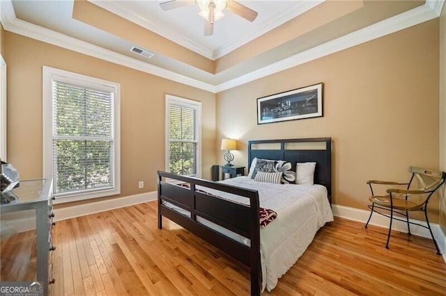 bedroom featuring light hardwood / wood-style flooring, crown molding, and ceiling fan