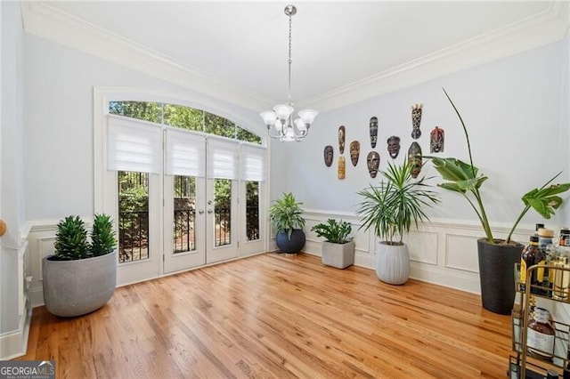 interior space featuring crown molding, light hardwood / wood-style flooring, and a chandelier