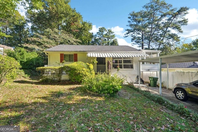 view of front of property with a front yard and a carport