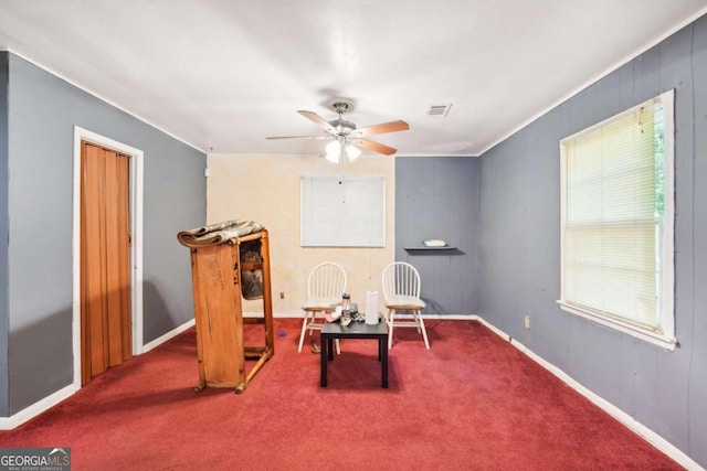 living area featuring carpet flooring and ceiling fan