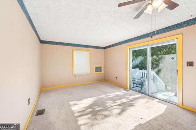 carpeted spare room with a textured ceiling and ceiling fan