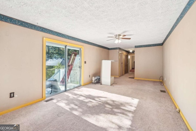 carpeted empty room featuring a textured ceiling and ceiling fan