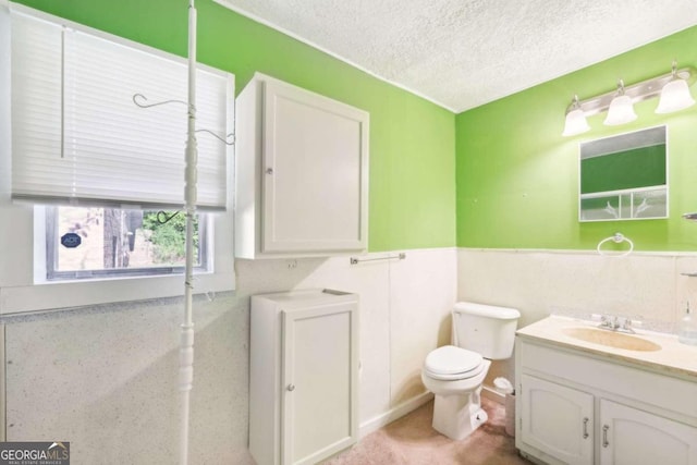 bathroom with toilet, a textured ceiling, and vanity