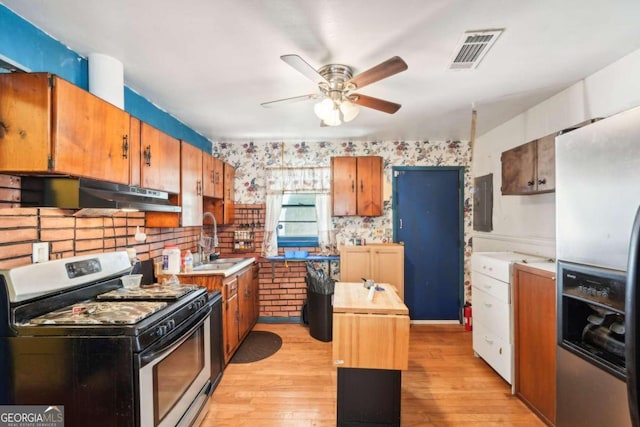 kitchen featuring appliances with stainless steel finishes, sink, a center island, light hardwood / wood-style floors, and range hood