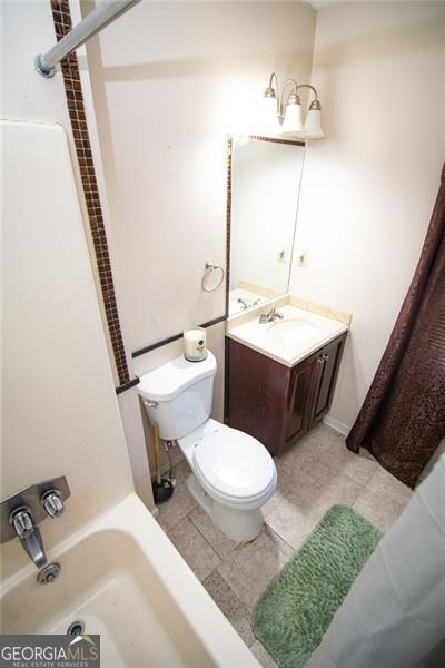 full bathroom featuring vanity, shower / bath combo, toilet, and tile patterned floors