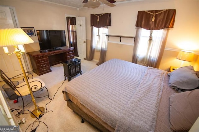 carpeted bedroom with ceiling fan and crown molding