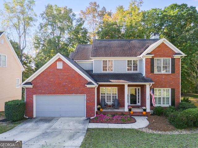 view of property with covered porch and a garage