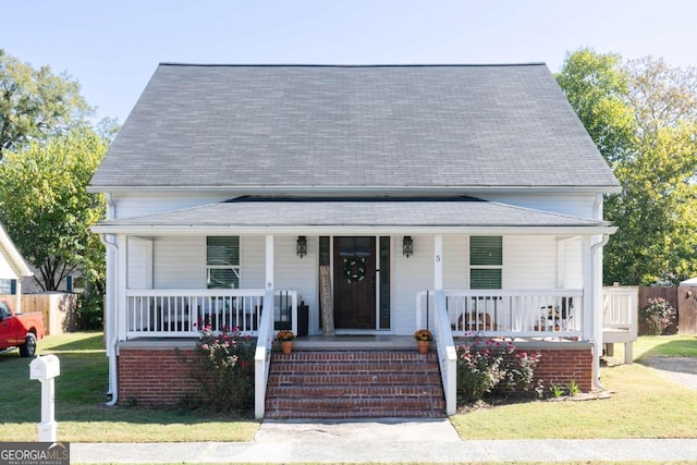 view of front of home featuring covered porch and a front yard