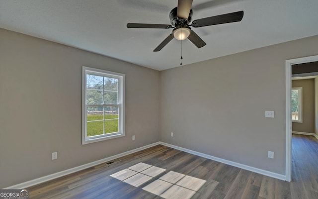 empty room featuring a textured ceiling, dark wood-type flooring, and ceiling fan