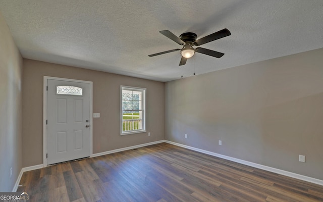 entrance foyer with ceiling fan, a textured ceiling, and dark hardwood / wood-style flooring