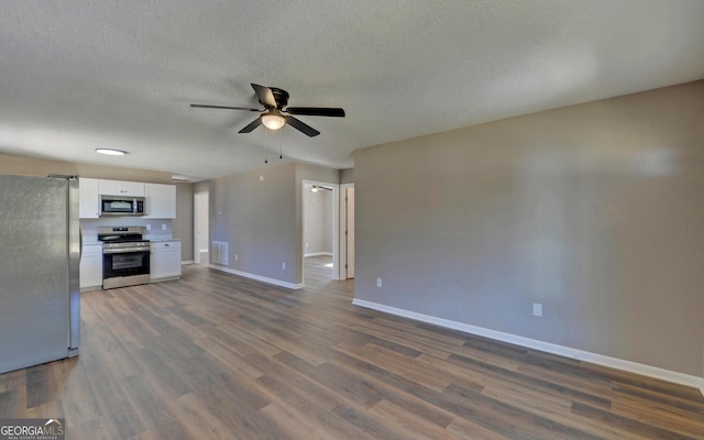 unfurnished living room with dark wood-type flooring, ceiling fan, and a textured ceiling