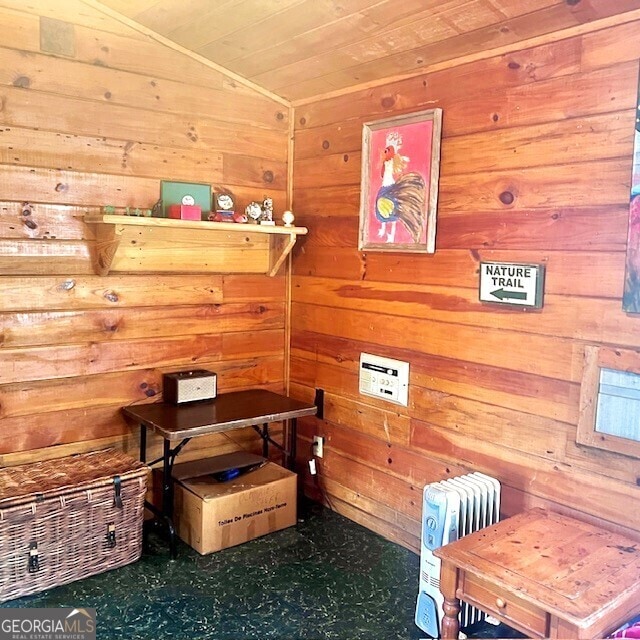 interior space featuring vaulted ceiling, wood ceiling, and wooden walls