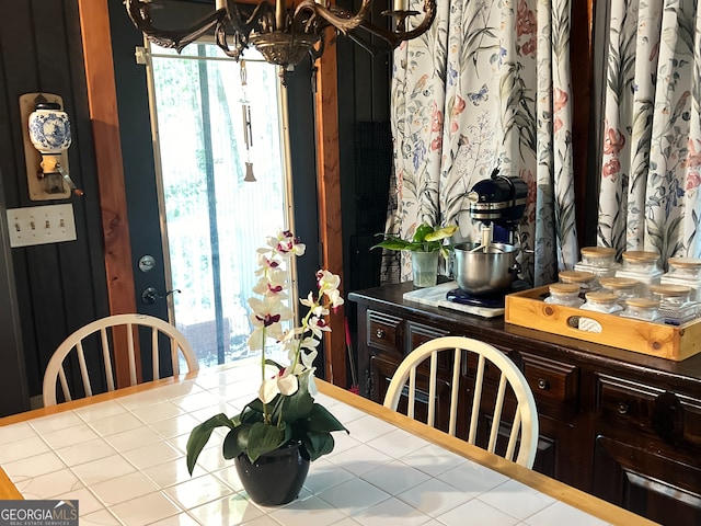 dining space with an inviting chandelier, a wealth of natural light, and light tile patterned flooring