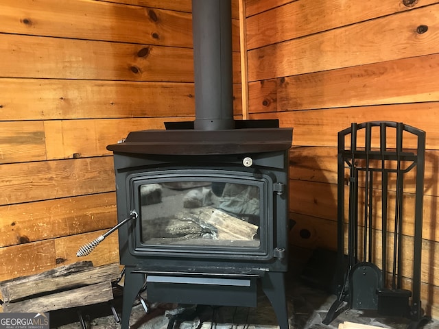 interior details featuring wooden walls and a wood stove