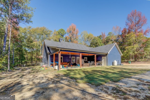 back of property with a patio area and a lawn