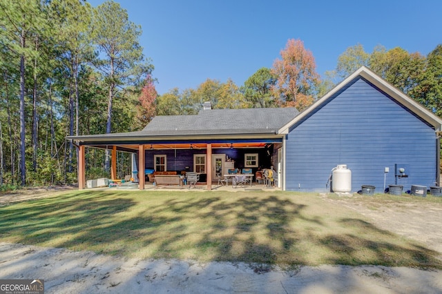 back of house with a patio and a lawn