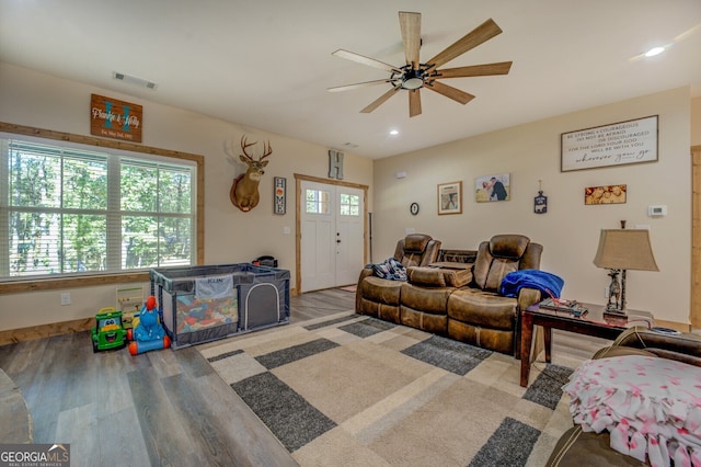 living room featuring wood-type flooring and ceiling fan