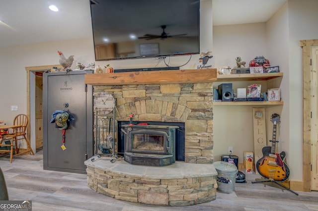 details featuring hardwood / wood-style flooring, a wood stove, and ceiling fan