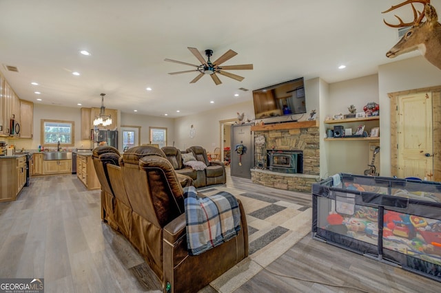 living room featuring light hardwood / wood-style floors, sink, and ceiling fan with notable chandelier