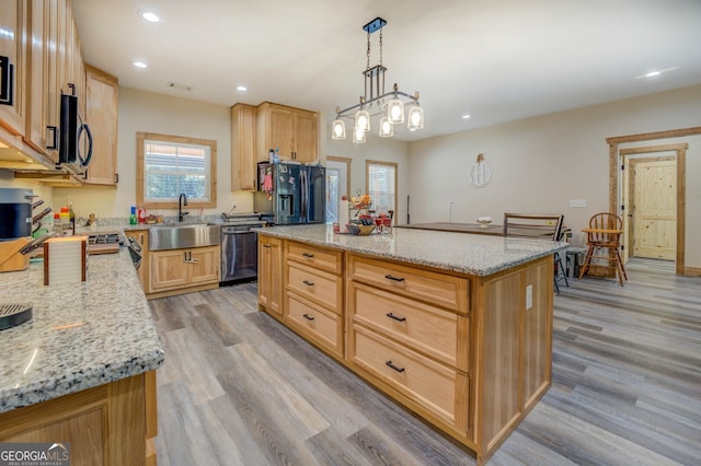 kitchen with dishwasher, light stone countertops, a center island, fridge with ice dispenser, and light hardwood / wood-style floors